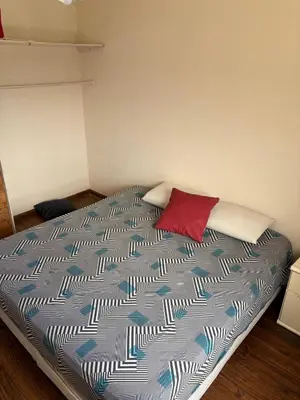 a bedroom with a large bed with a red pillow at Depto Vista panoramica in Villa Carlos Paz