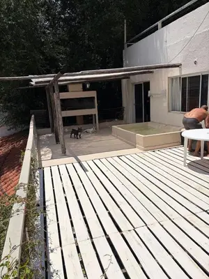a wooden deck with a cat sitting on top of it at Depto Vista panoramica in Villa Carlos Paz