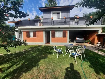 a yard with chairs and a table in front of a house at CASA PARA 6 PERSONAS - Mis Dos Soles in Mina Clavero