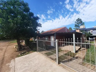a fence in front of a building with a tree at CASA PARA 6 PERSONAS - Mis Dos Soles in Mina Clavero