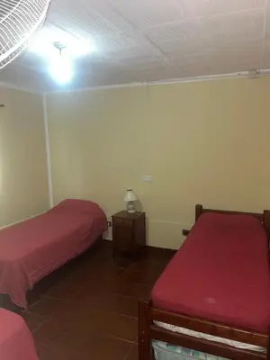 a bedroom with two beds and a light on the ceiling at CASA PARA 6 PERSONAS - Mis Dos Soles in Mina Clavero