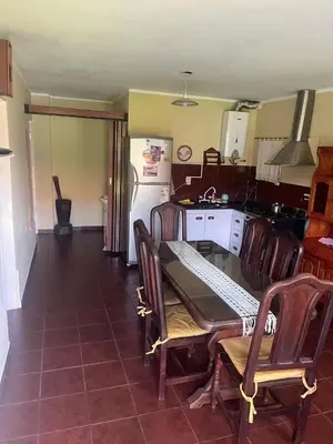 a kitchen with a table and chairs and a refrigerator at CASA PARA 6 PERSONAS - Mis Dos Soles in Mina Clavero