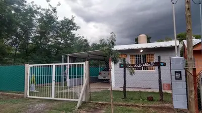 a white house with a gate and a fence at La estrella Anisacate in Villa Anizacate