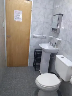 a bathroom with a toilet and a sink and a door at La estrella Anisacate in Villa Anizacate