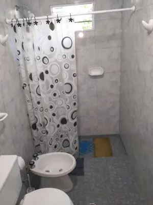 a bathroom with a toilet and a shower curtain at La estrella Anisacate in Villa Anizacate