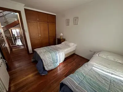 a bedroom with two beds and a wooden floor at Casa en CORDOBA in Cordoba