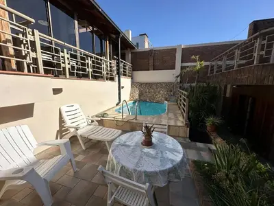 a patio with a table and chairs and a pool at Casa en CORDOBA in Cordoba