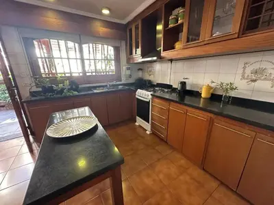 a kitchen with wooden cabinets and a black counter top at Casa en CORDOBA in Cordoba