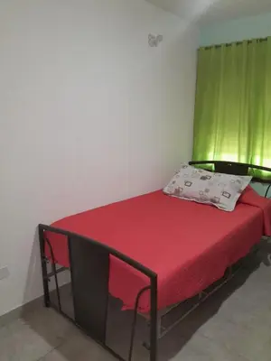 a bed in a room with a green curtain at Mi mirador in Bialet Massé