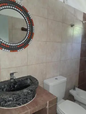 a bathroom with a sink and a toilet and a mirror at Mi mirador in Bialet Massé