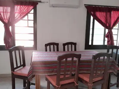 a dining room with a table and chairs and windows at Mi mirador in Bialet Massé
