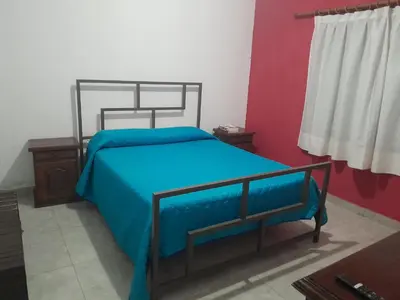 a bedroom with a bed with a blue blanket at Mi mirador in Bialet Massé