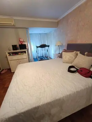 a bedroom with a white bed with a red bag on it at Bienvenidos a casa in Cordoba