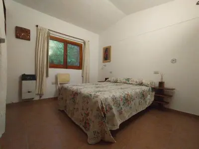 a bedroom with a bed and a window at Descanso en Tanti - Turismo y Bienestar in Tanti