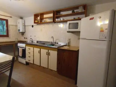 a kitchen with a white refrigerator and a sink at Descanso en Tanti - Turismo y Bienestar in Tanti
