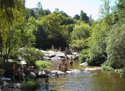 a group of people in the water in a river at Descanso en Tanti - Turismo y Bienestar in Tanti