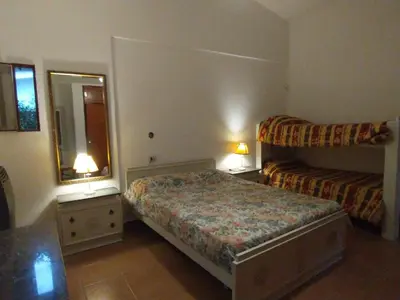 a small bedroom with a bed and a mirror at Descanso en Tanti - Turismo y Bienestar in Tanti