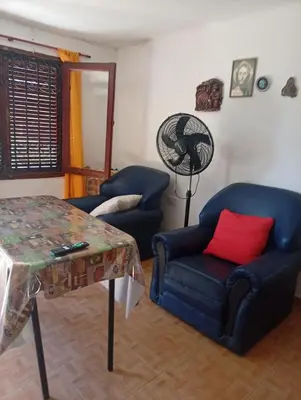 a living room with two blue chairs and a table at Cabañas los Materos 3 in Santa María