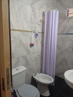 a bathroom with a white toilet and a sink at Cabañas los Materos 3 in Santa María