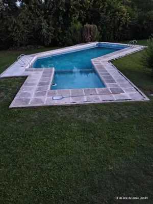 a swimming pool with a path around it at Complejo Costa Garay in Potrero de Garay