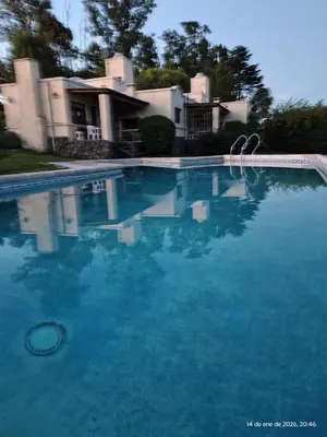 a large blue swimming pool in front of a house at Complejo Costa Garay in Potrero de Garay