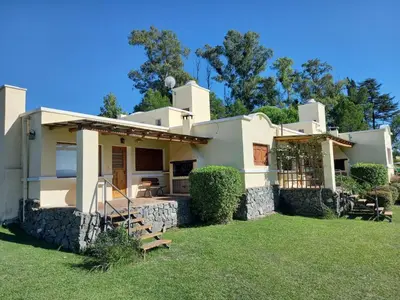 a large white house with a green yard at Complejo Costa Garay in Potrero de Garay