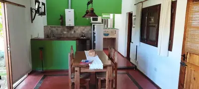 a kitchen with a wooden table and green walls at Complejo Costa Garay in Potrero de Garay