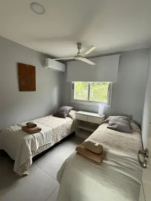 two beds in a bedroom with a ceiling fan at Complejo Palo Blanco in Villa Carlos Paz