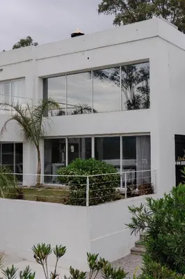a white house with a lot of windows at Complejo Palo Blanco in Villa Carlos Paz
