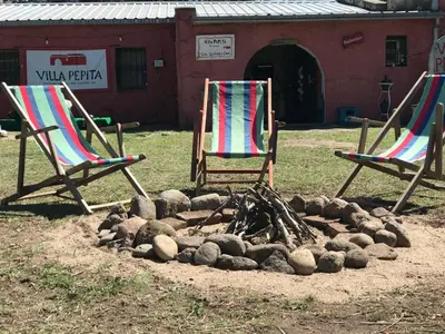 three lawn chairs sitting in front of a fire at Villa Pepita in Villa Quillinzo