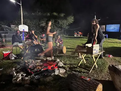 a group of people standing around a camp fire at Villa Pepita in Villa Quillinzo