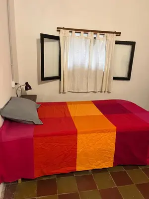 a bedroom with a colorful blanket on a bed at Hospedaje San Javier in San Javier