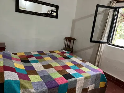 a bedroom with a colorful quilt on a bed at Hospedaje San Javier in San Javier