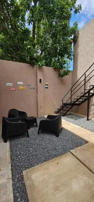 a group of black chairs on gravel next to a building at LitStay - San Martin in Cordoba