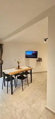 a dining room with a table and a tv on a wall at LitStay - San Martin in Cordoba