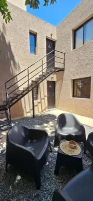 two chairs and a table in front of a building at LitStay - San Martin in Cordoba