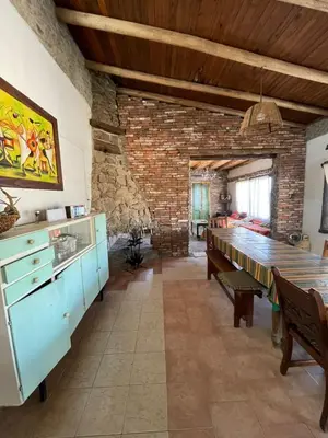 a dining room with a table and a brick wall at La Vision, Casa de campo in Villa Quillinzo