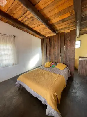 a large bed in a room with wooden ceilings at La Vision, Casa de campo in Villa Quillinzo