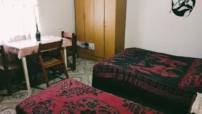 a room with two beds and a table and a table and chair at depto santa maria in Santa María