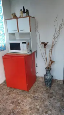 a microwave on top of a red cabinet with a vase at depto santa maria in Santa María