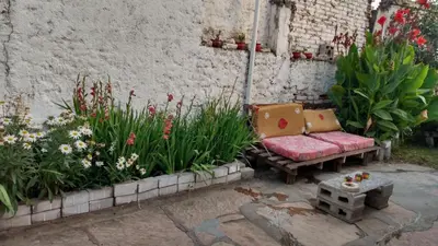 a couch sitting in the middle of some flowers at depto santa maria in Santa María
