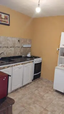 a kitchen with a stove and a white refrigerator at casa para cosquin rock in Santa María