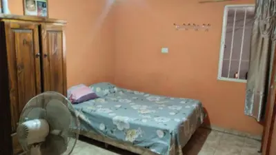 a small bedroom with a bed and a fan at casa para cosquin rock in Santa María