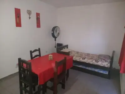 a room with a red table and chairs and a bed at Cabañas Sucot in Tanti