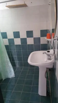 a bathroom with a sink and green and white tiles at Cabañas Sucot in Tanti