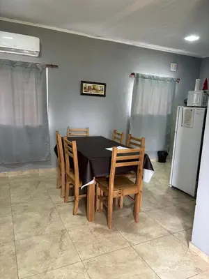 a dining room with a table and chairs and a refrigerator at MisdosolesCabañas in Bialet Massé