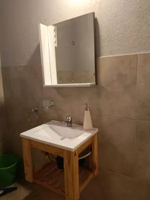 a bathroom with a white sink and a mirror at MisdosolesCabañas in Bialet Massé