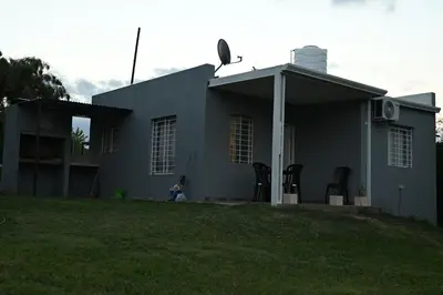 a gray house with a lawn in front of it at MisdosolesCabañas in Bialet Massé
