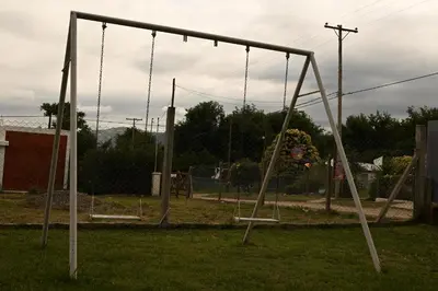 an empty swing set in a park at MisdosolesCabañas in Bialet Massé