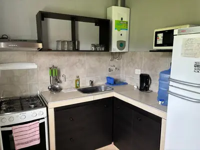 a kitchen with a sink and a stove at MisdosolesCabañas in Bialet Massé